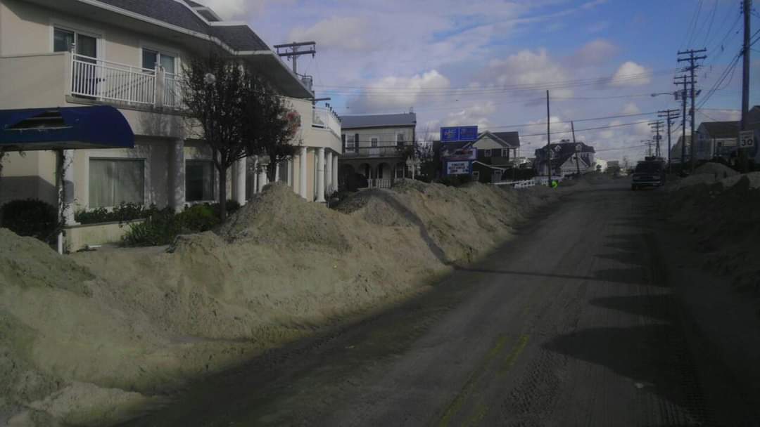 Sandy street with houses and blue sky.