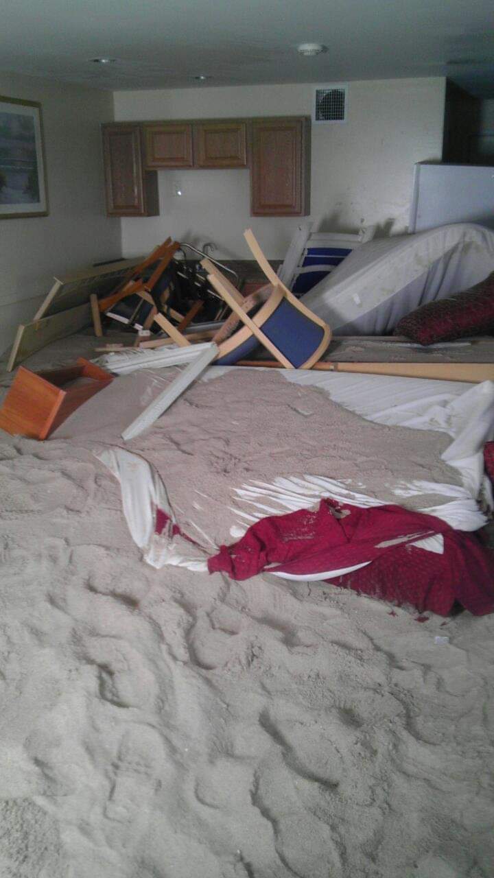 Room filled with sand and overturned furniture.