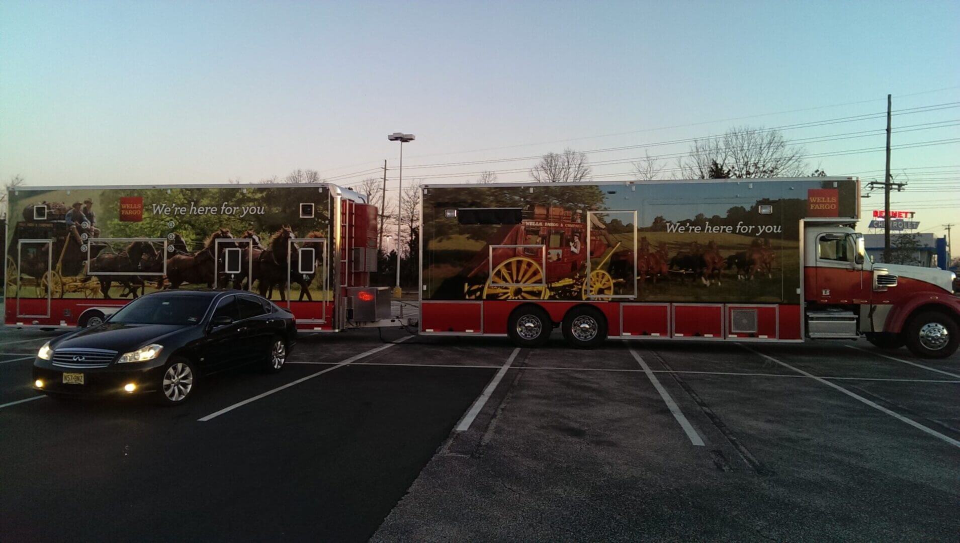 A colorful carnival game booth set up outdoors at dusk.