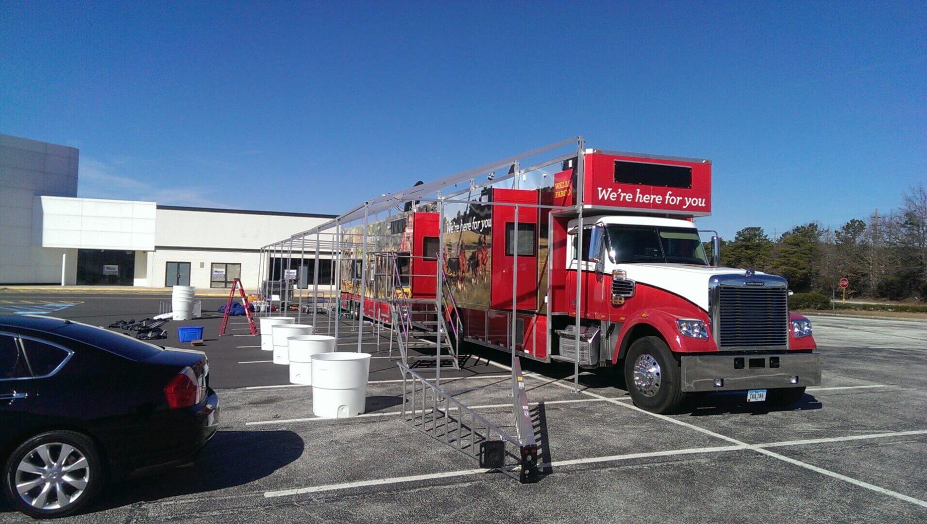 Red fire truck being cleaned with scaffolding around it under a clear blue sky.