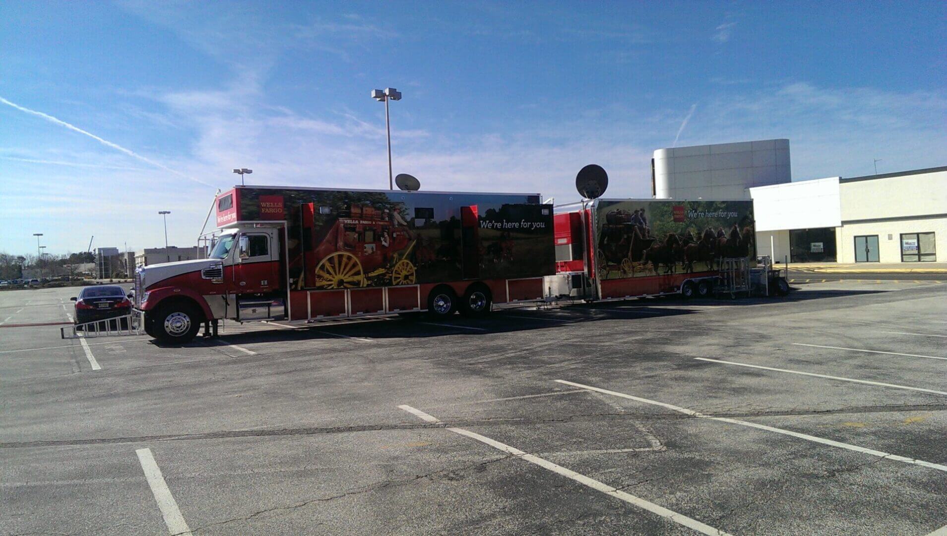 A decorated fire truck parked in an empty lot under a clear blue sky.